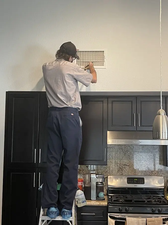 Technician inspecting an air vent during HVAC service in Pittstown